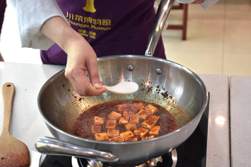 Clarissa Wei adds a starch mixture as the mapo tofu simmers in the pan.